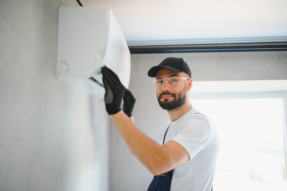 Technician,man,in,uniform,installing,,repairing,air,conditioner.,construction,and